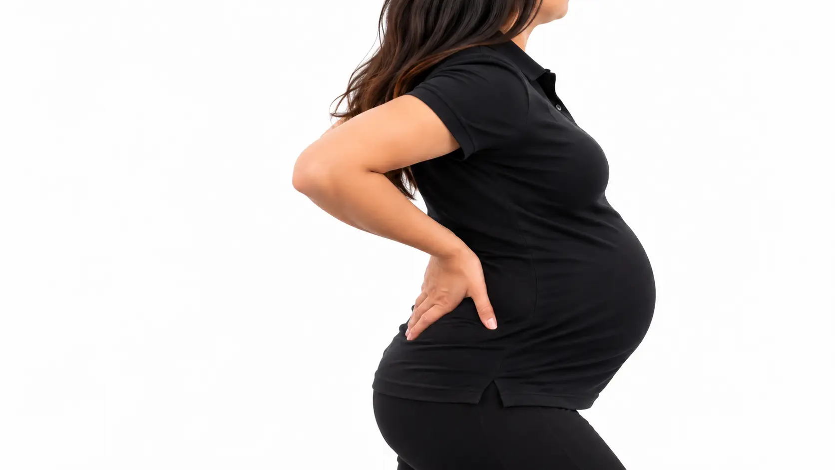 Side view of a pregnant woman in a black shirt and pants, holding her lower back.